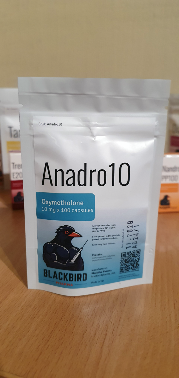 A product display of Anadro10 (Oxymetholone 10 mg/capsule) on a wooden tabletop.