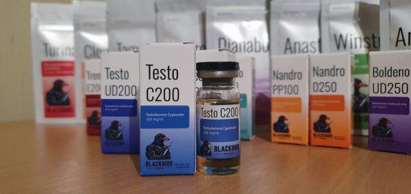 A product display of Testo C200 (Testosterone Cypionate 200 mg/ml) on a wooden tabletop.